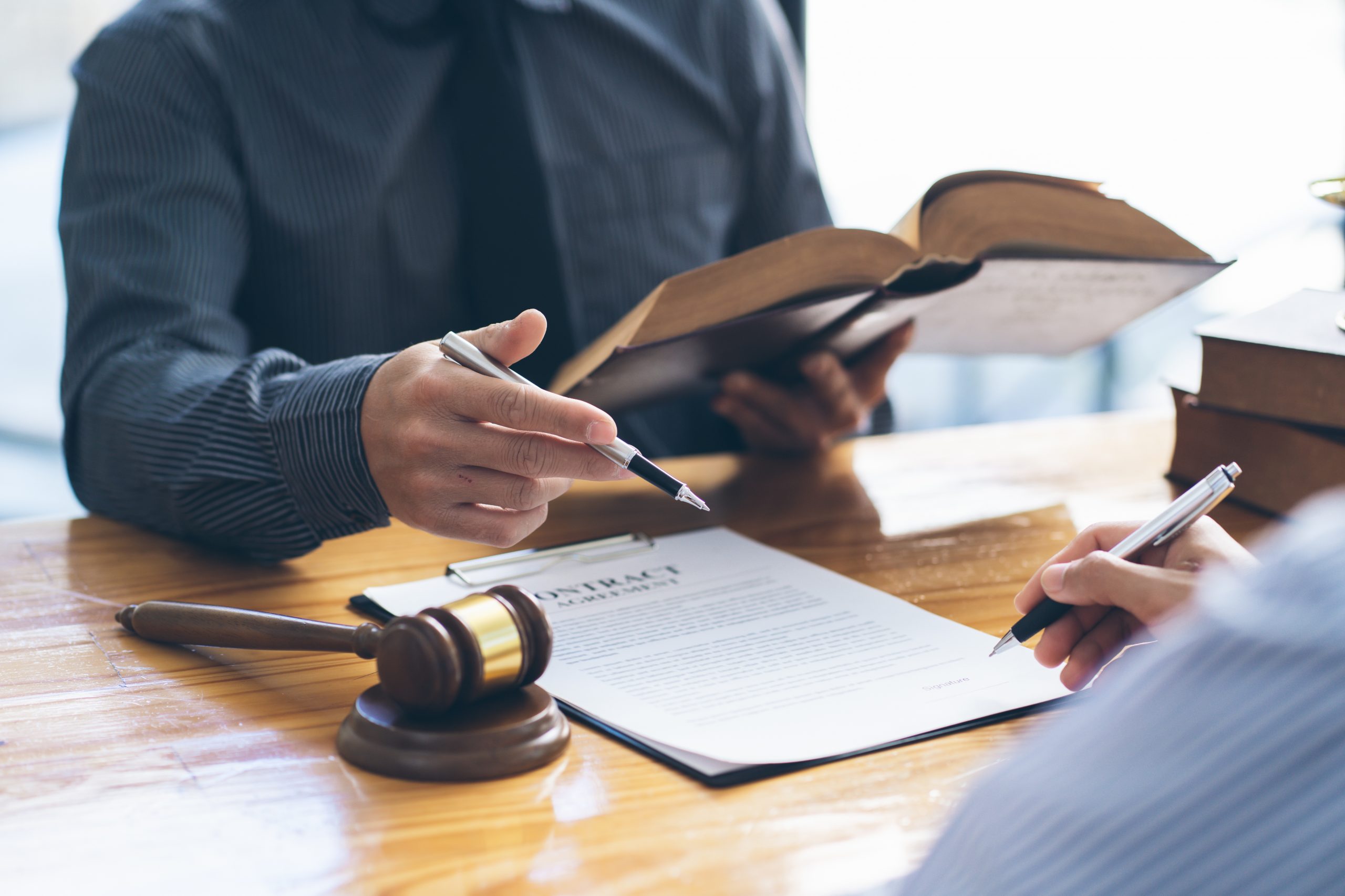 Business people negotiating a contract. Human hands working with documents at desk and signing contract, lawyer concept